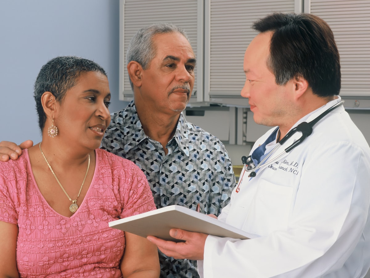 A doctor talking with a patient and her husband
